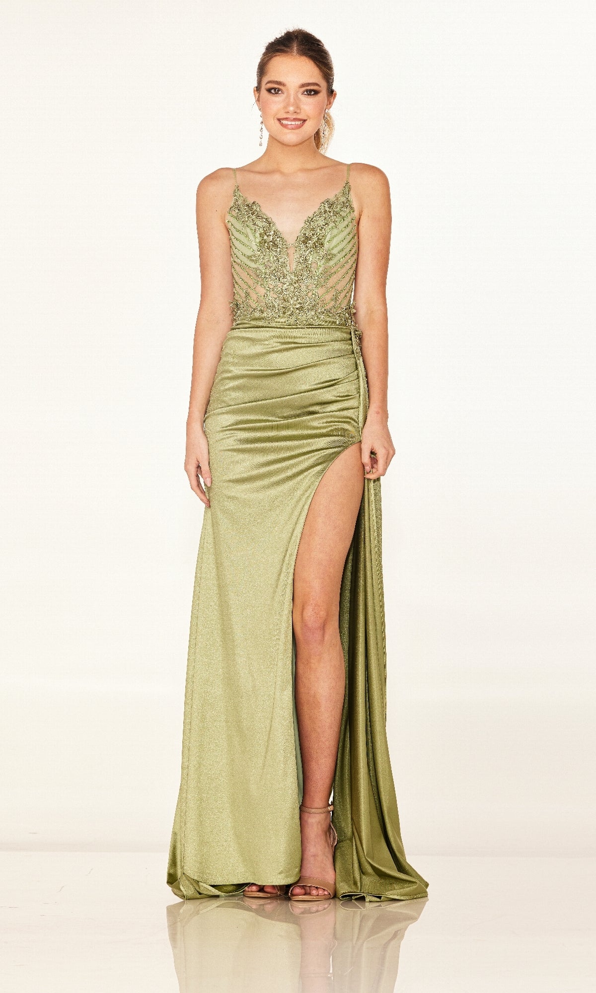 A woman stands facing forward against a plain background, wearing the Cecilia Couture 2610 long prom dress in light green with a form-fitting silhouette, lace sheer bodice, thin straps, and high leg slit.